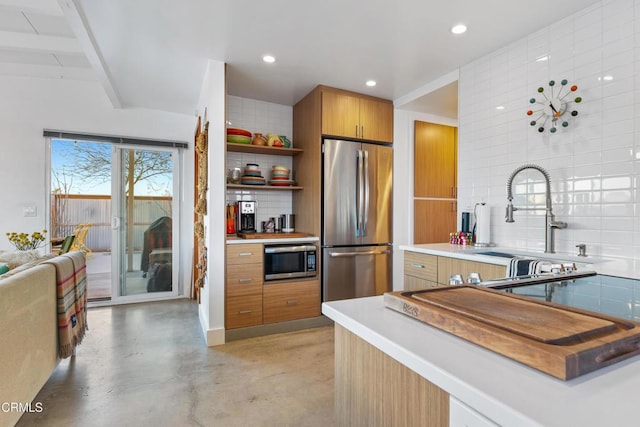 kitchen with appliances with stainless steel finishes, sink, beam ceiling, and decorative backsplash