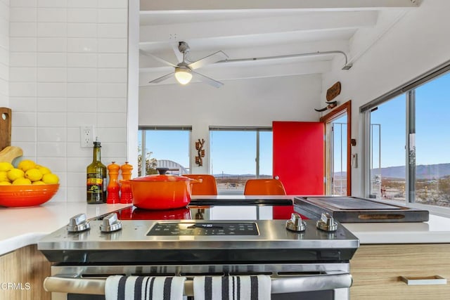 kitchen with tasteful backsplash, ceiling fan, beam ceiling, and a mountain view