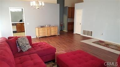 living room featuring a notable chandelier and dark wood-type flooring