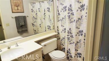 bathroom with vanity, a shower with shower curtain, and toilet