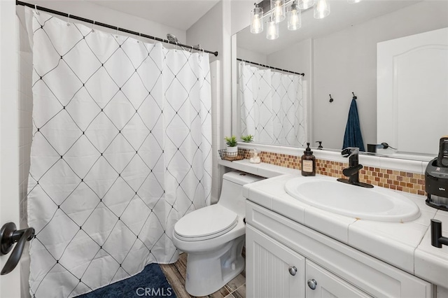 bathroom featuring backsplash, hardwood / wood-style floors, vanity, and toilet