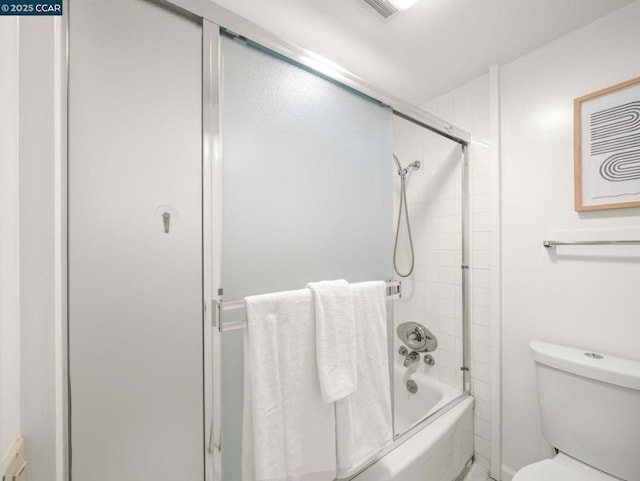 bathroom featuring enclosed tub / shower combo and toilet