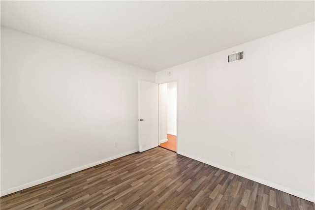 unfurnished room featuring dark wood-type flooring