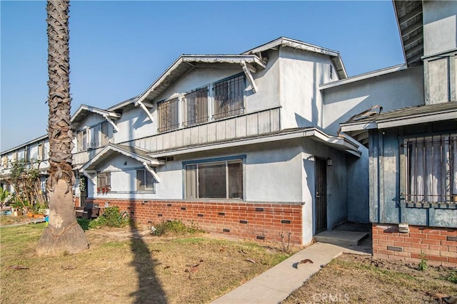 view of front of property with a balcony and a front lawn