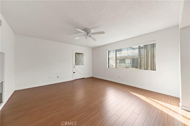 spare room featuring a textured ceiling, ceiling fan, and dark hardwood / wood-style floors