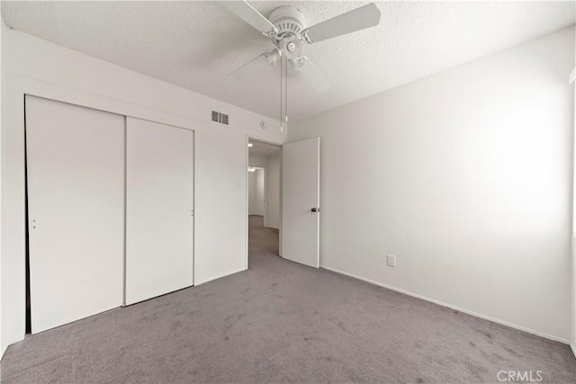 unfurnished bedroom featuring light carpet, a closet, and ceiling fan