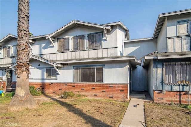 townhome / multi-family property with a balcony and a front lawn