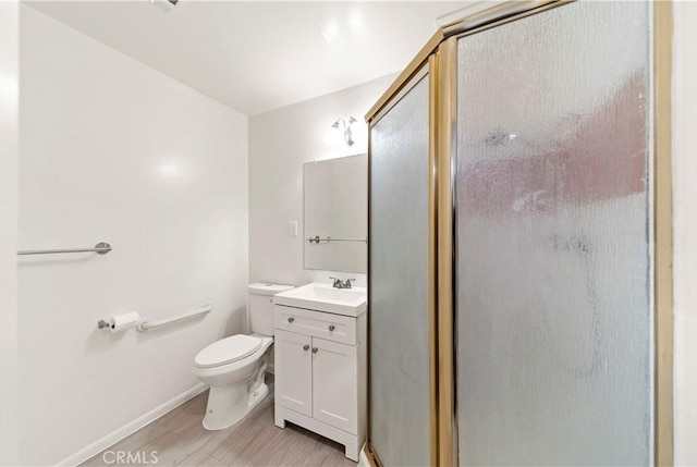 bathroom with toilet, an enclosed shower, and vanity