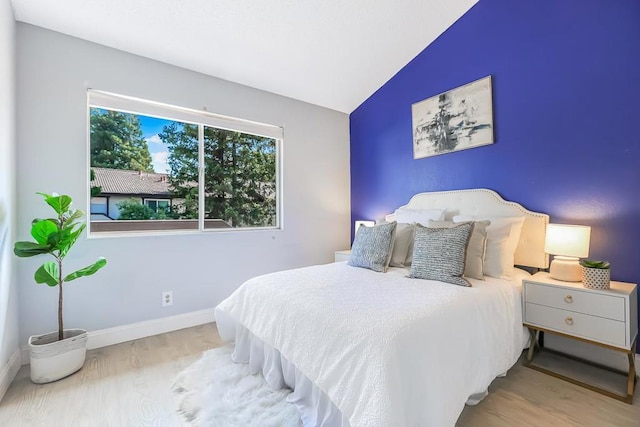 bedroom featuring vaulted ceiling and light hardwood / wood-style flooring