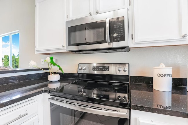 kitchen featuring white cabinetry, dark stone counters, and appliances with stainless steel finishes