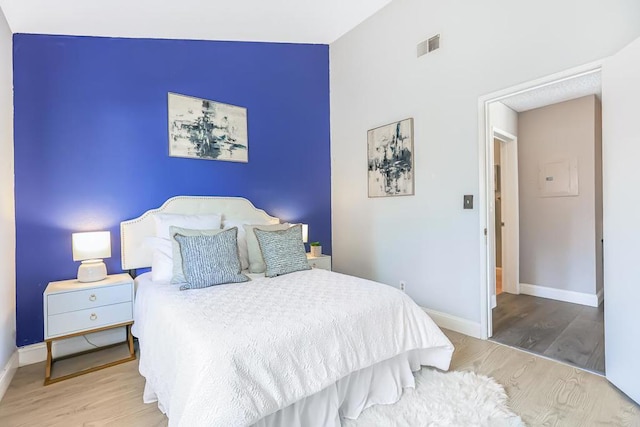 bedroom featuring lofted ceiling and light wood-type flooring