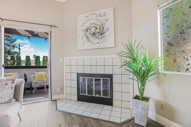 living room featuring a tiled fireplace and hardwood / wood-style floors