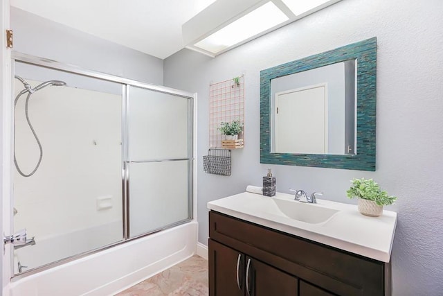 bathroom with vanity and shower / bath combination with glass door