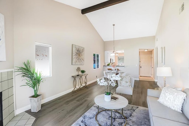 living room featuring wood-type flooring, high vaulted ceiling, and beamed ceiling