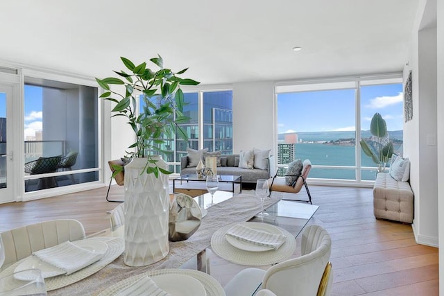 living room featuring hardwood / wood-style floors, plenty of natural light, expansive windows, and a water view