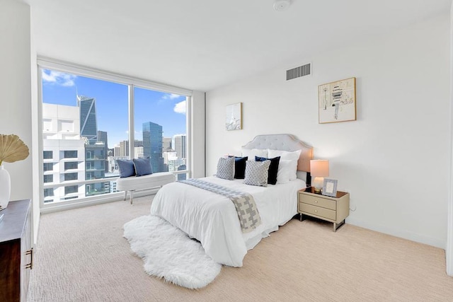 bedroom featuring light carpet and floor to ceiling windows