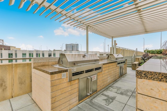 view of patio featuring a pergola, a grill, and an outdoor kitchen