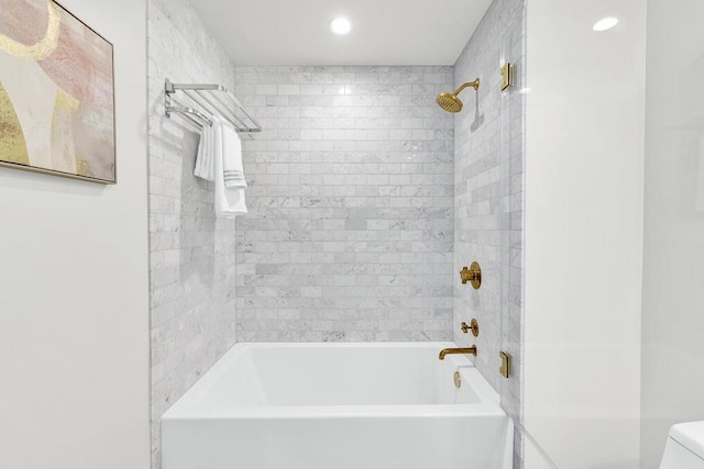 bathroom with tiled shower / bath combo and toilet