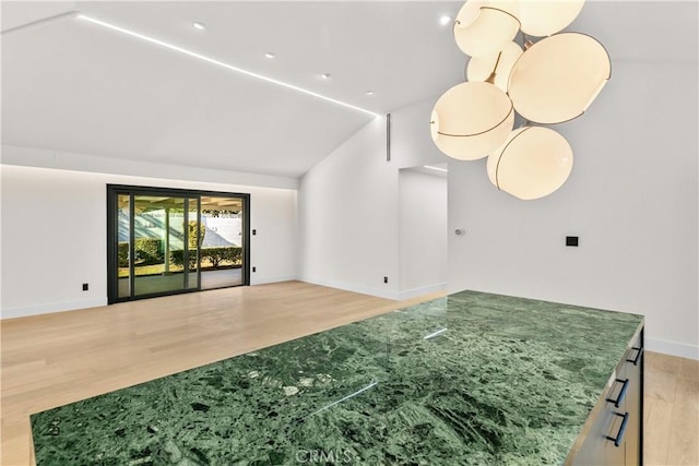 living room featuring lofted ceiling and light hardwood / wood-style floors