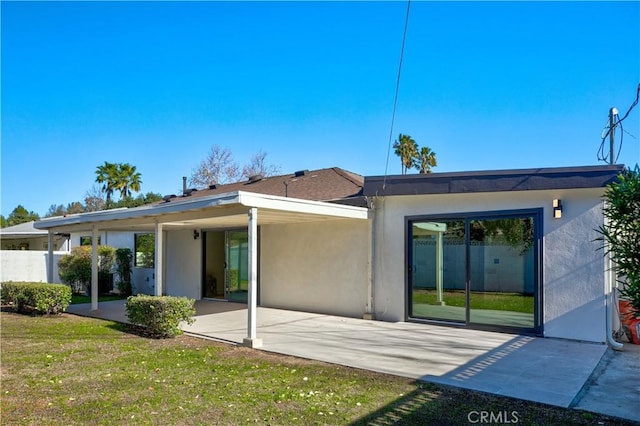 rear view of property featuring a yard and a patio area