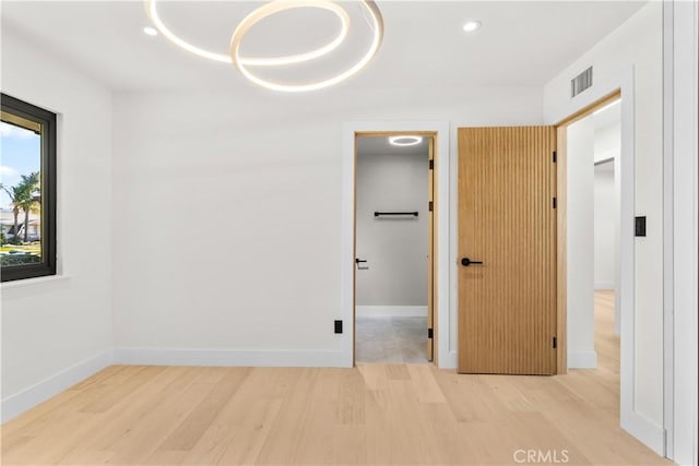 unfurnished bedroom featuring light hardwood / wood-style floors and a closet