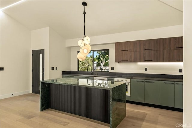 kitchen with sink, decorative light fixtures, dark brown cabinets, a kitchen island, and wall oven