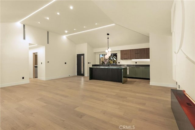 unfurnished living room featuring high vaulted ceiling and light wood-type flooring