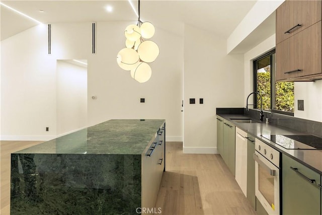 kitchen featuring sink, dark stone countertops, a center island, wall oven, and black electric cooktop