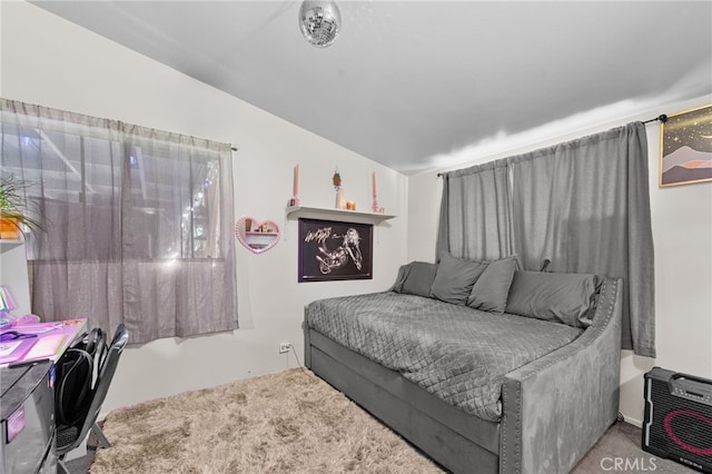 bedroom with carpet flooring and lofted ceiling