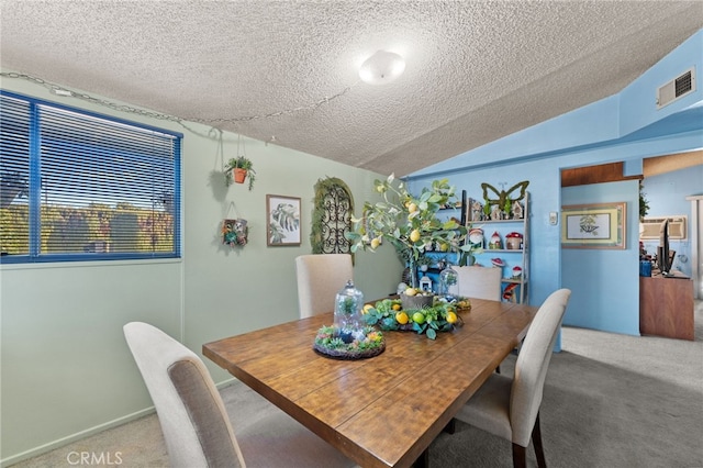 carpeted dining area with a textured ceiling and lofted ceiling