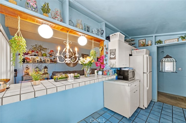 kitchen with tile counters, white refrigerator, and light tile patterned floors