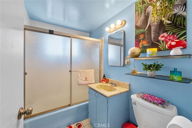 full bathroom with tile patterned floors, vanity, toilet, and bath / shower combo with glass door