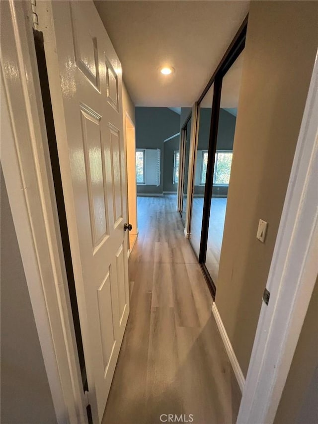 hall featuring floor to ceiling windows and light hardwood / wood-style floors