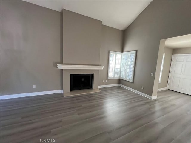 unfurnished living room with high vaulted ceiling and hardwood / wood-style flooring