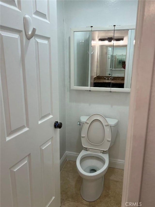 bathroom with toilet and tile patterned flooring