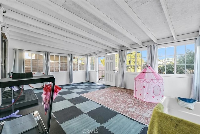 sunroom / solarium featuring vaulted ceiling with beams