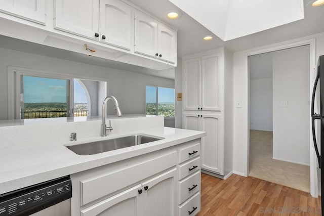 kitchen featuring plenty of natural light, dishwasher, white cabinets, and sink