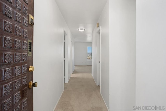 corridor featuring light colored carpet