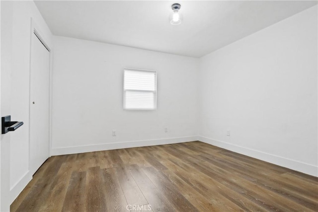 unfurnished room with dark wood-type flooring