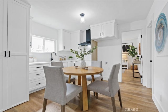 dining area with sink and light hardwood / wood-style floors