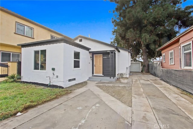 view of front facade featuring a garage, an outbuilding, and a front yard