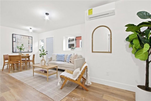 living room with light hardwood / wood-style floors and a wall mounted air conditioner