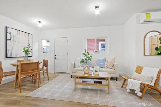 living room featuring light wood-type flooring and an AC wall unit