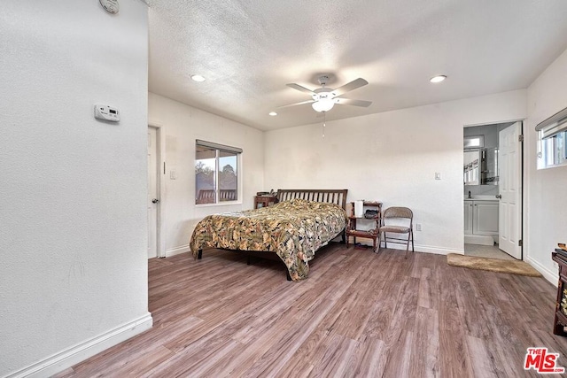 bedroom with hardwood / wood-style floors, ceiling fan, a textured ceiling, and multiple windows