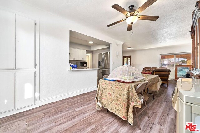 dining area featuring ceiling fan, a textured ceiling, and hardwood / wood-style flooring