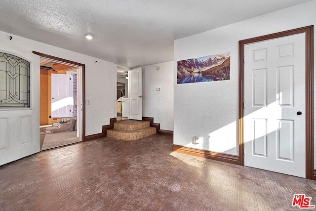 unfurnished living room with wood-type flooring, a textured ceiling, and ceiling fan