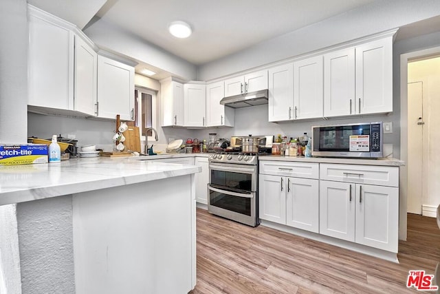 kitchen with sink, light hardwood / wood-style flooring, light stone counters, white cabinetry, and stainless steel appliances