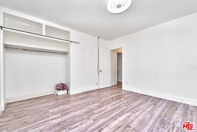 unfurnished bedroom with light hardwood / wood-style floors and a closet