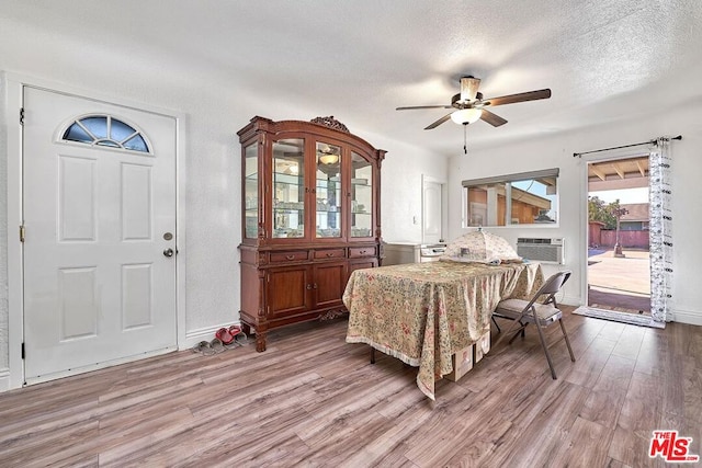 dining area with a textured ceiling, light hardwood / wood-style flooring, and ceiling fan