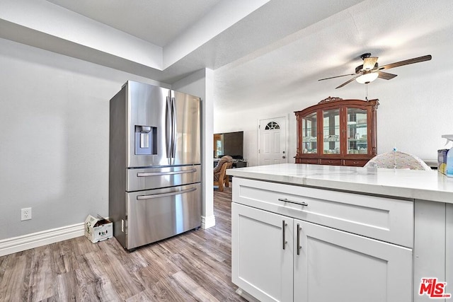 kitchen with white cabinets, ceiling fan, stainless steel fridge with ice dispenser, and light hardwood / wood-style flooring